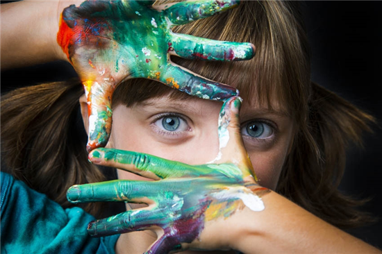 image of a school girl with craft paint on her hands